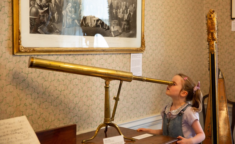 Little girl looking through telescope at Herschel Museum of Astronomy